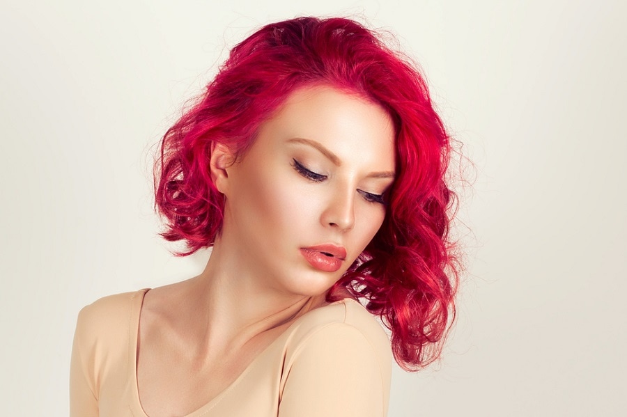 woman with dark red layered curly bob