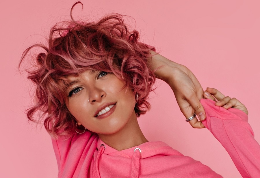 curly shaggy bob with pastel pink highlights