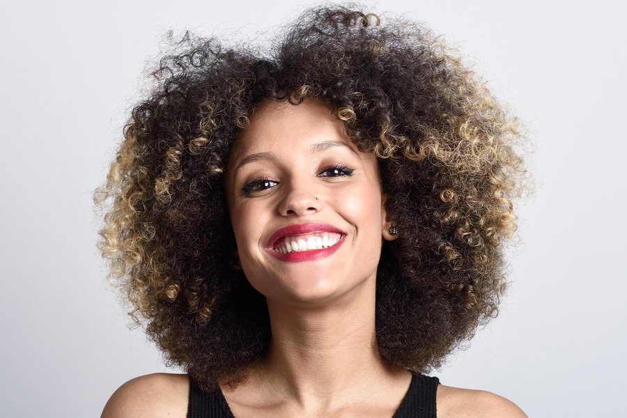 mixed girl curly afro hair with blonde highlights