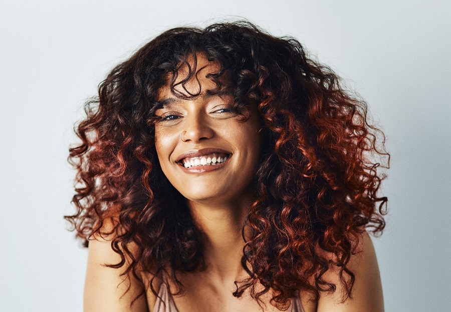 mixed girl curly hair with copper highlights