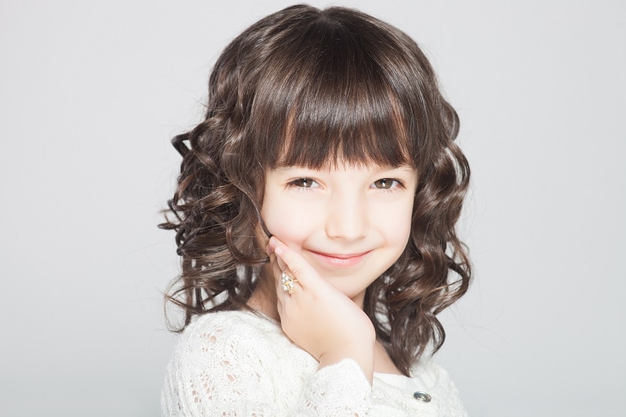 curly flower girl hairstyle thick bangs