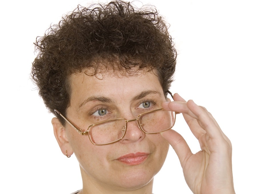 short curly hairstyle for women over 50 with glasses