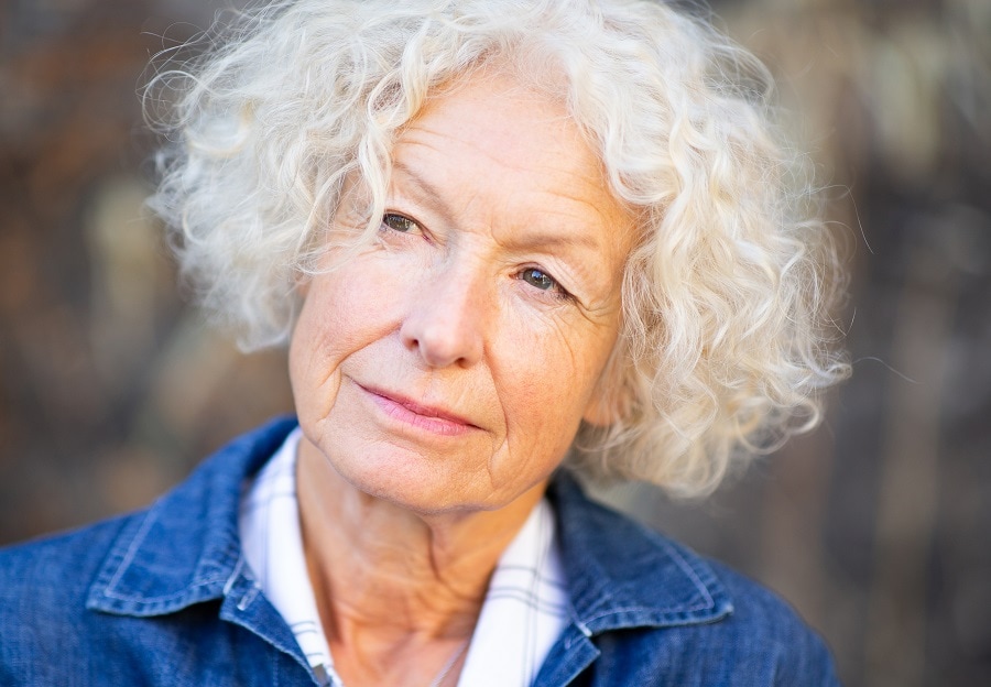 woman over 60 with short curly hair and square face