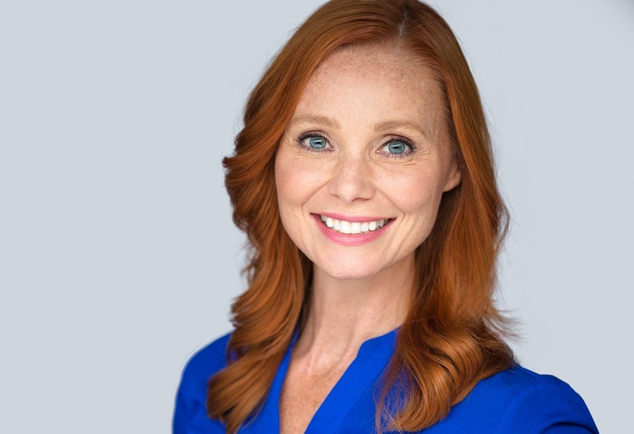 older woman with long layered auburn hair