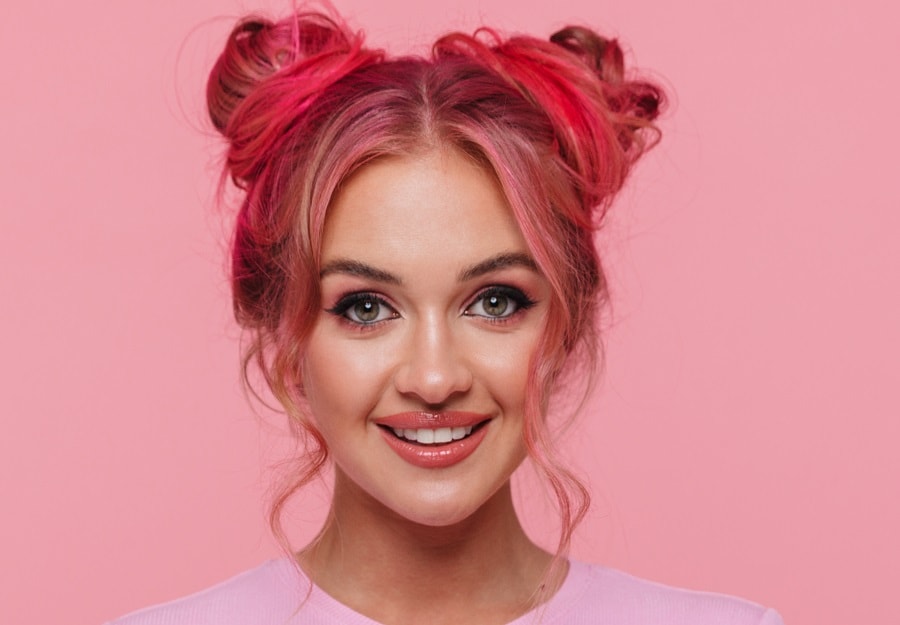 curly space buns with pastel pink hair