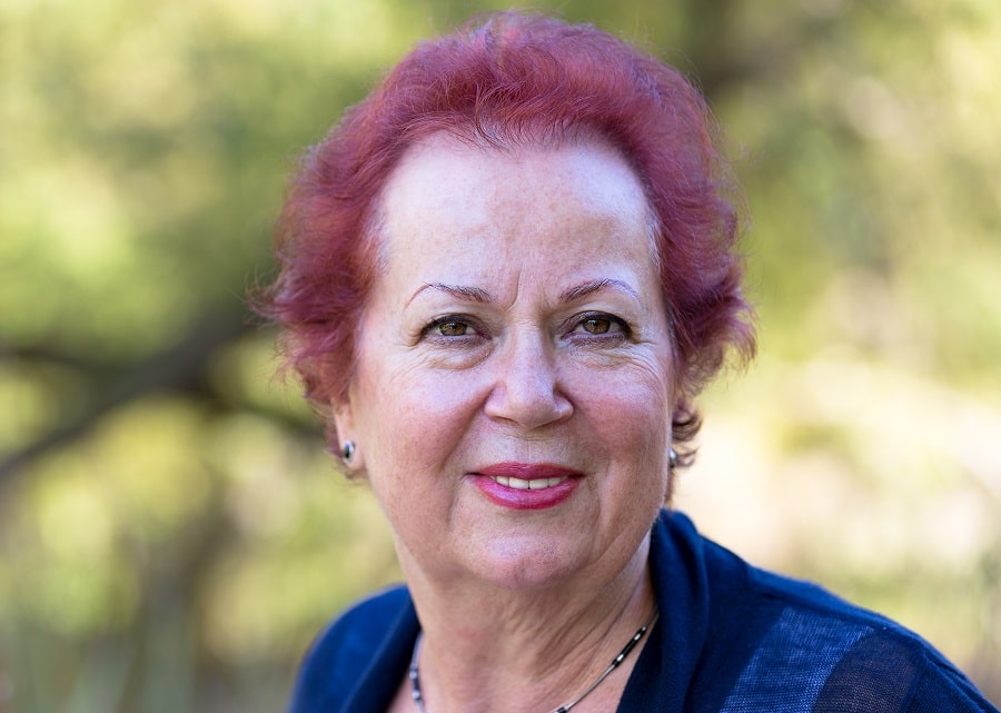 woman over 70 with short burgundy red hair