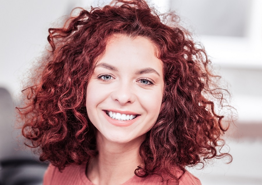 frizzy hairstyle with dark red hair